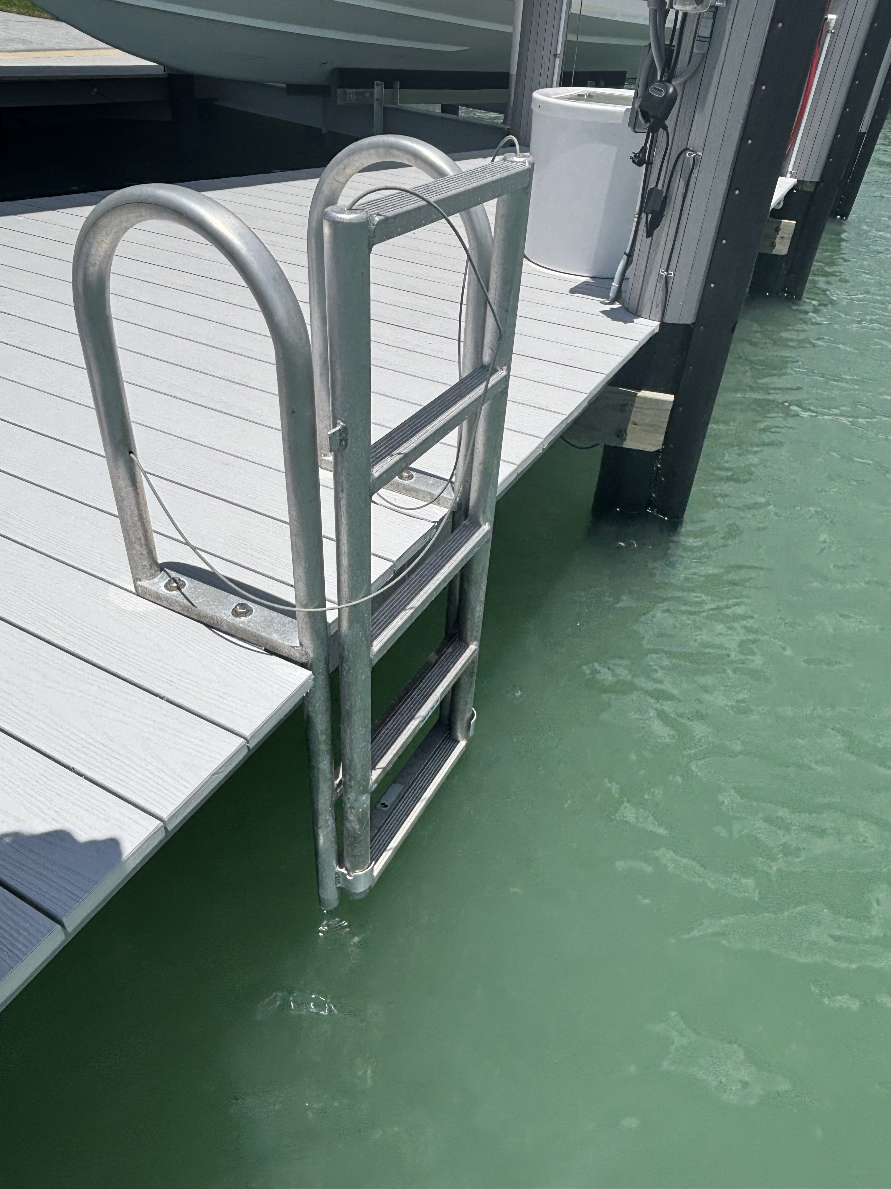 Heavy-duty aluminum boarding ladder with cable safety line for climbing in from the water.