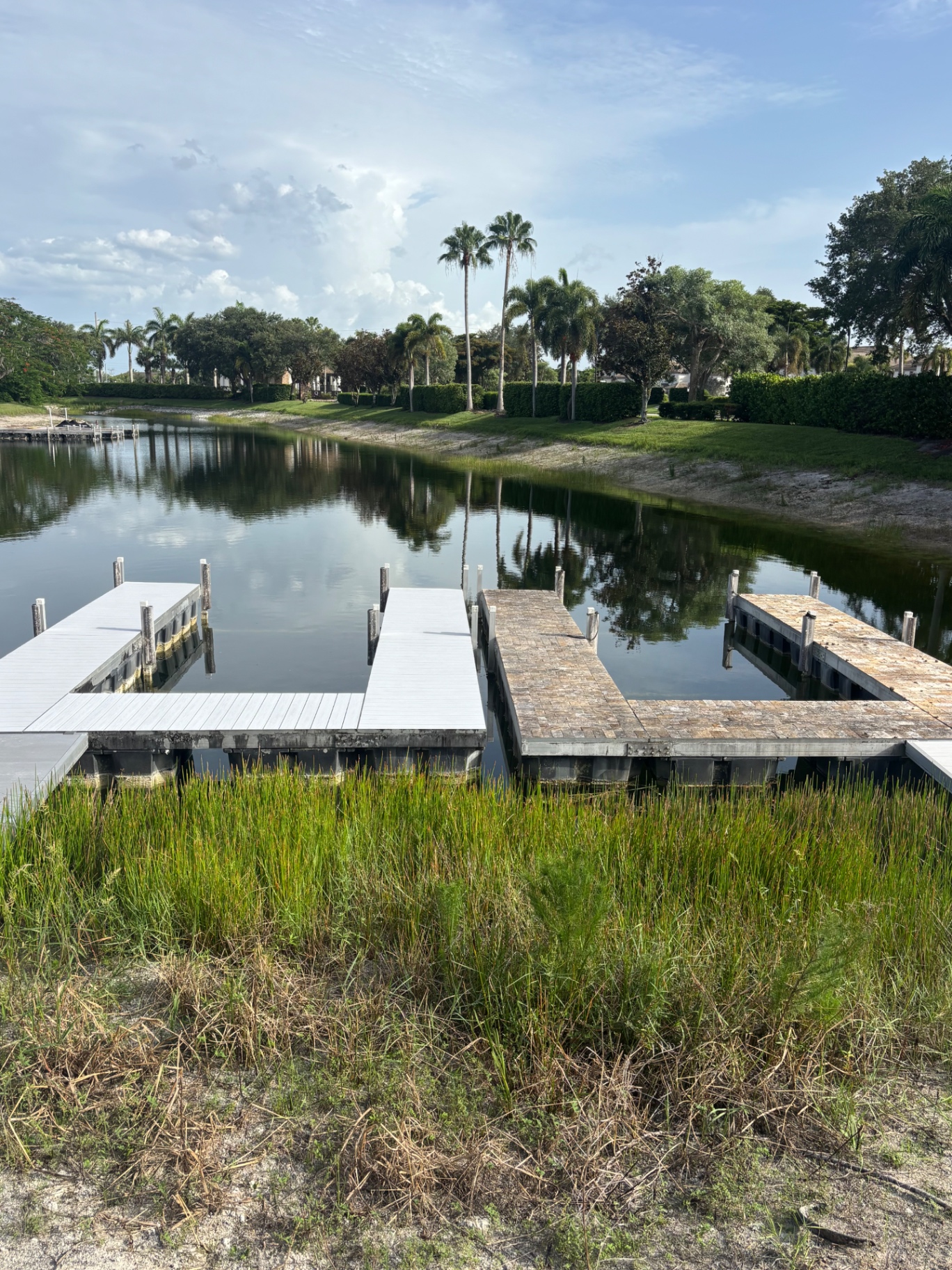 Final wide shot — same footprint the customer had before, completely new dock on top. Left side is the finished composite rebuild, right side is the untouched original paver dock for reference.