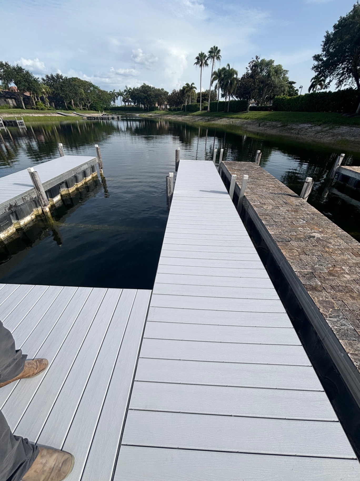 Finished dock from the walk-on end — new composite runs the full length of the finger, matched height and squared up at every transition.